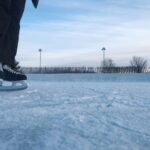 person in black pants and black shoes standing on snow covered ground during daytime