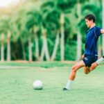 man trying to kick soccer ball