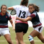 women in black and white jersey shirt playing soccer
