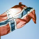 a flag flying in the wind with a blue sky in the background